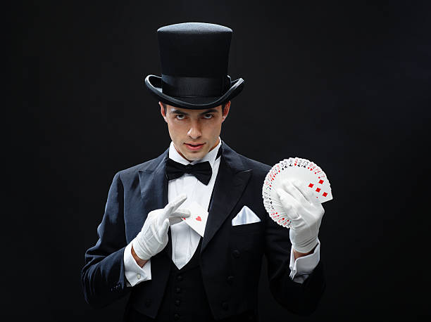 magician showing trick with playing cards magic, performance, circus, gambling, casino, poker and  show concept - magician in top hat showing trick with playing cards magic trick photos stock pictures, royalty-free photos & images