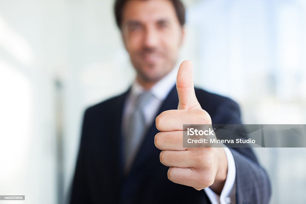 A blurry image of a businessman giving a clear thumbs up Portrait of a smiling businessman giving thumbs up Thumbs Up Stock Photo