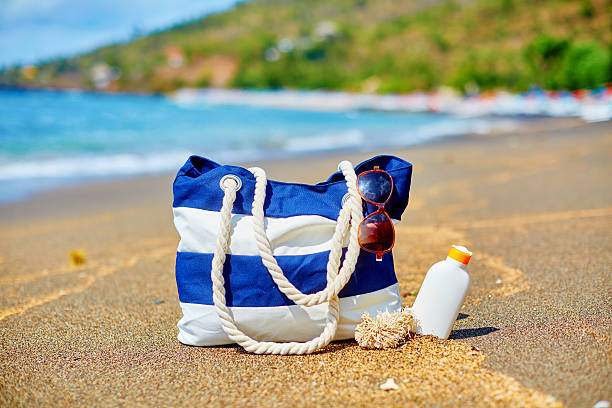 istock Beach bag, flip flops and sunscreen on beach 465051972
