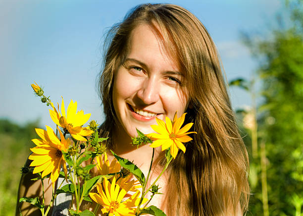 若い女性、黄色の花畑 ストックフォト