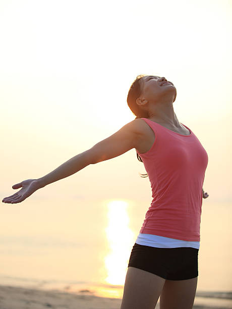 istock woman open arms at sunset/sunrise beach 465055487