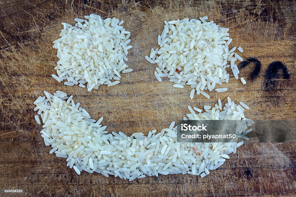 Rice grains Rice grains form of smile on a wooden background. 2015 Stock Photo