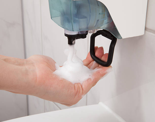 Hand using soap dispenser Closeup of hand using soap dispenser in bathroom change dispenser stock pictures, royalty-free photos & images