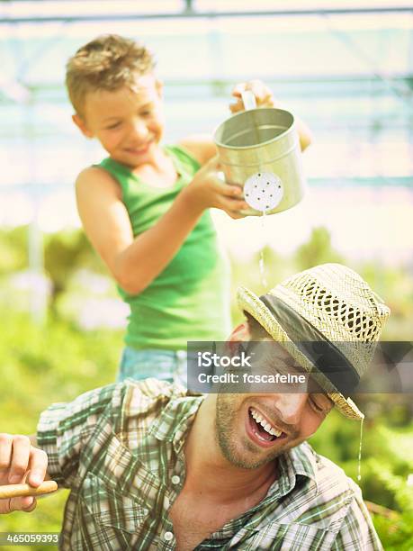 Young Boy Playing With His Father In A Green House Stock Photo - Download Image Now - Activity, Adult, Boys
