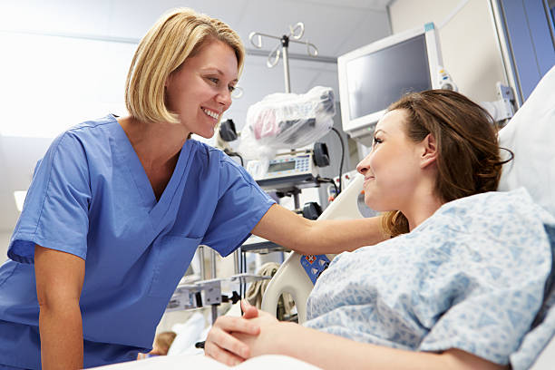 giovane femmina paziente parlando all'infermiere in pronto soccorso - patient female hospital recovery foto e immagini stock