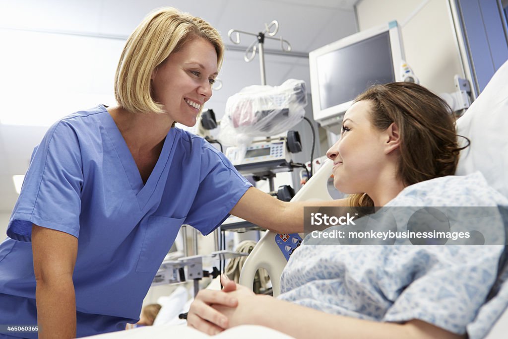Young Female Patient Talking To Nurse In Emergency Room Laid Down Smiling Young Female Patient Talking To Nurse In Emergency Room Patient Stock Photo