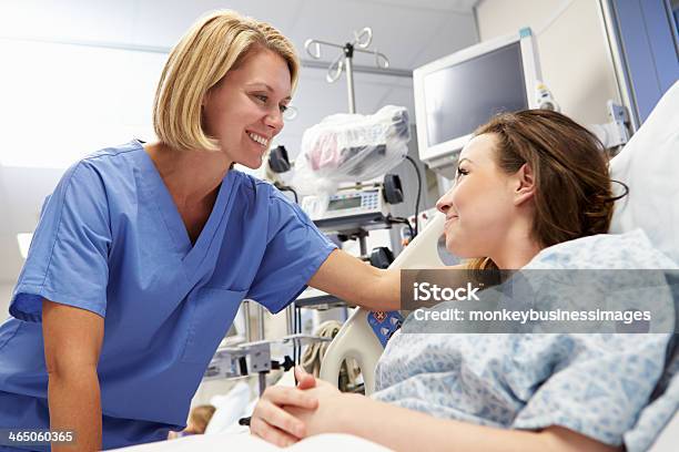 Young Female Patient Talking To Nurse In Emergency Room Stock Photo - Download Image Now