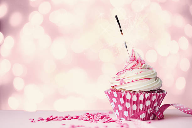 istock A pink and white polkadot cupcake with a burned out sparkler 465063284
