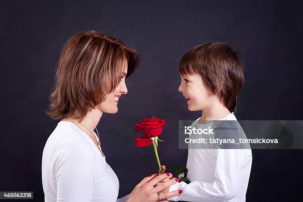 Young Kid Giving Gorgeous Red Rose To His Mom Stock Photo - Download Image Now - Boys, Giving, Rose - Flower