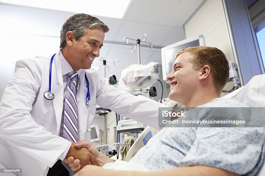Молодой мужчина пациента, разговаривающего с врачом в отделение не�отложной помощи - Стоковые фото Врач роялти-фри