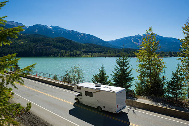 RV Road Trip RV driving along a spectacular section of Highway 99 past Green Lake in Whistler, BC rv stock pictures, royalty-free photos & images