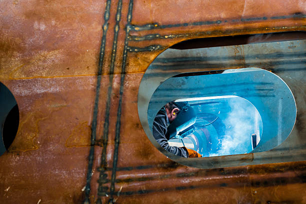 Welder working with mask on in a work shop 