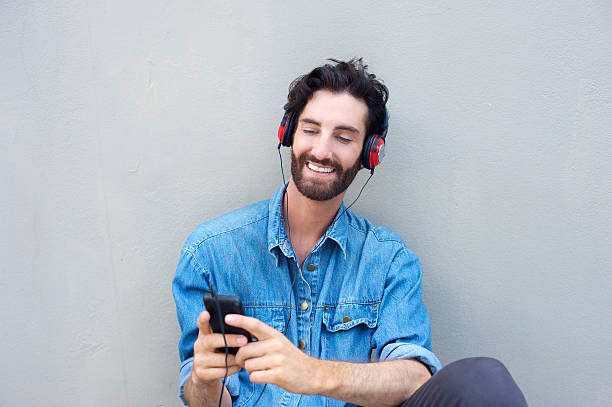 istock Handsome young man smiling with cellphone and headphones 465067962