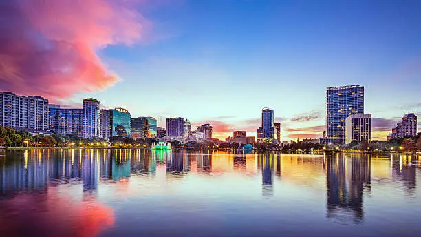 Orlando, Florida, USA downtown skyline on Eola Lake at dusk.