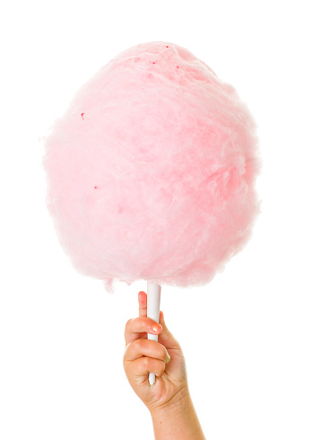 Stock photo of a hand holding pink cotton candy isolated on a white background.