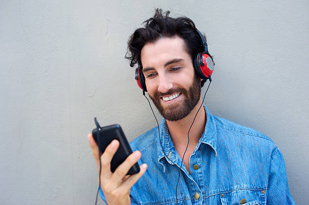 istock Happy man smiling with mobile phone and headphones 465072886