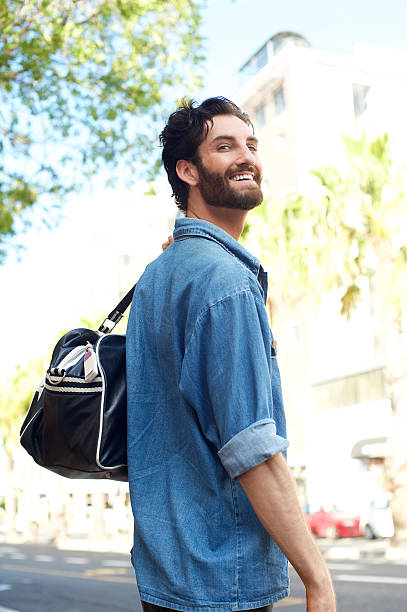 sorridente uomo con borsa in viaggio su strada - borsa monospalla foto e immagini stock