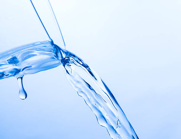 istock Cool Water Pouring from a Transparent Glass Cup 465075524
