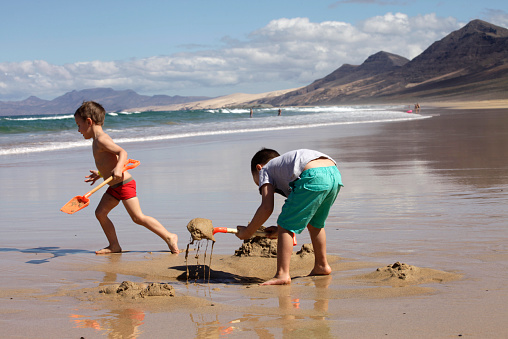 children playing on the beach. Sand and water