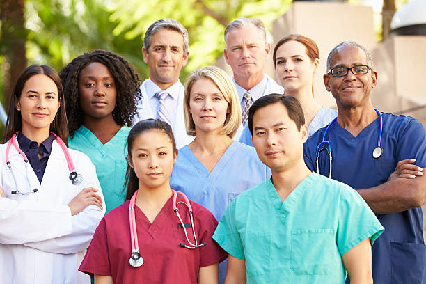 Portrait of 9 medical professionals Outdoor Portrait Of Medical Team Smiling At Camera medical occupation stock pictures, royalty-free photos & images