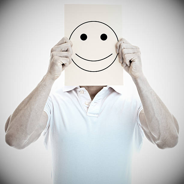 istock Young man with a happy smiley card covering face 465077060
