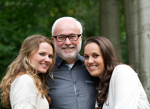 istock Happy father together with two smiling daughters 465078061