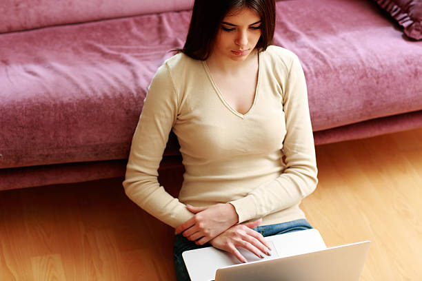 istock young beautiful woman sitting on the floor and using laptop 465081545