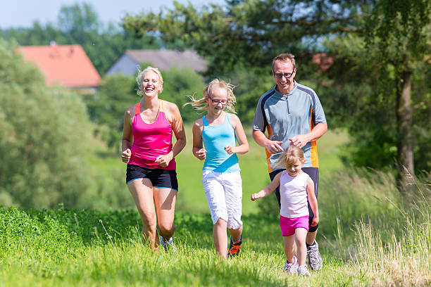 istock Family sport jogging through field 465081716