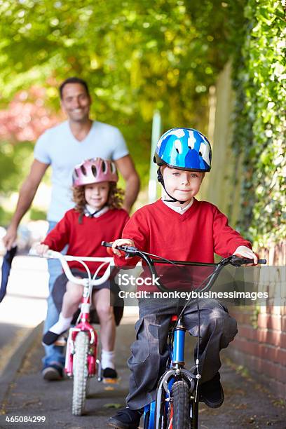 Two Children Riding Bikes With Their Father Stock Photo - Download Image Now - Child, Offspring, Cycling
