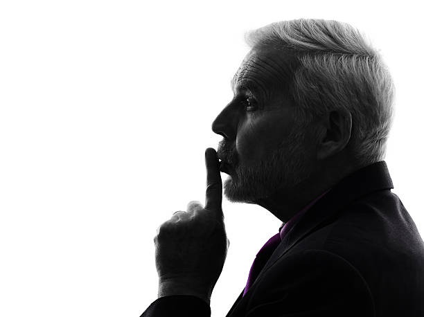 istock senior business man hushing finger on lips silhouette 465088294