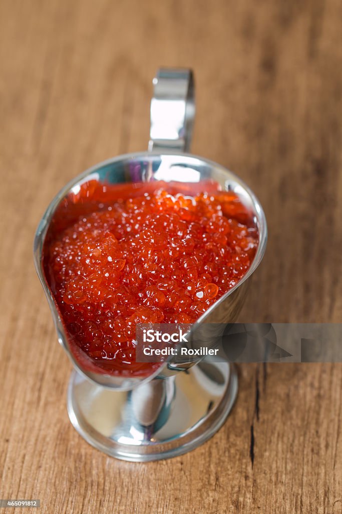 Red caviar in sauceboat Red caviar in sauceboat on wooden background 2015 Stock Photo