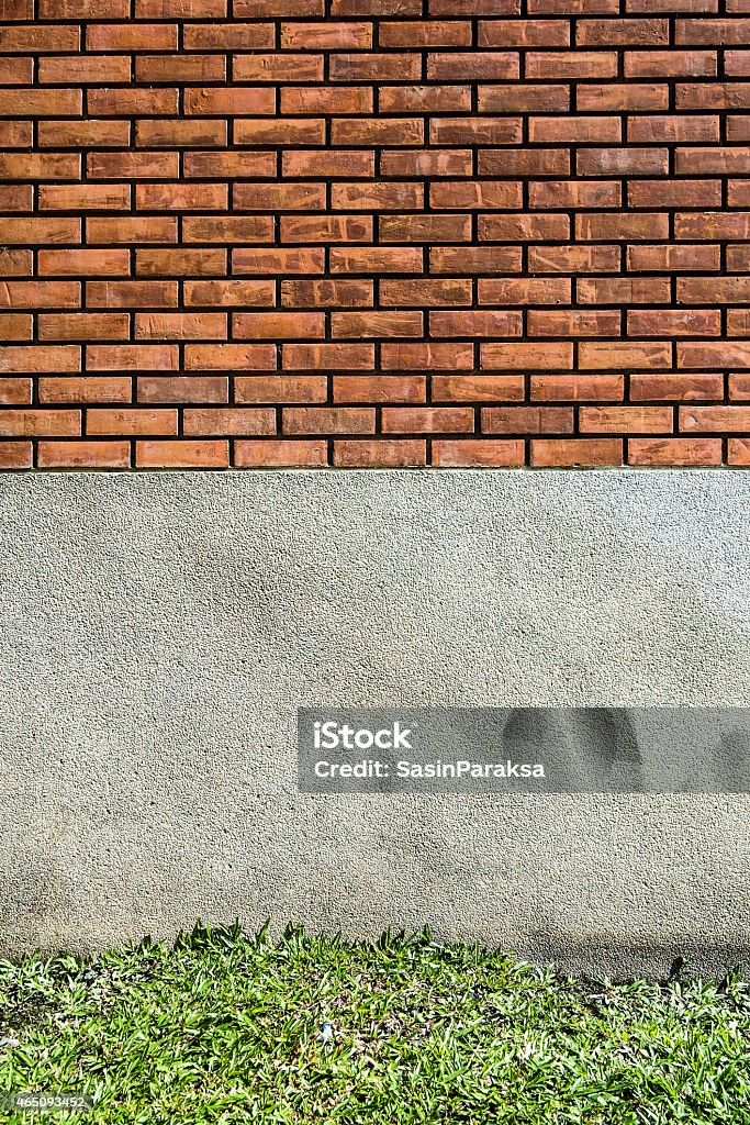 Old Brick Wall texture with gravel and grass below 2015 Stock Photo