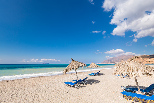 Beach chairs and sunshades at a very tranquil beach of the south shore of Creta, Greece.