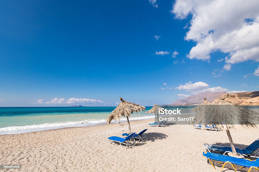 Vacation at Crete Beaches Beach chairs and sunshades at a very tranquil beach of the south shore of Creta, Greece. Crete Stock Photo