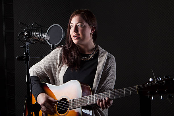 istock Young female guitar player singer sound recording studio 465095886