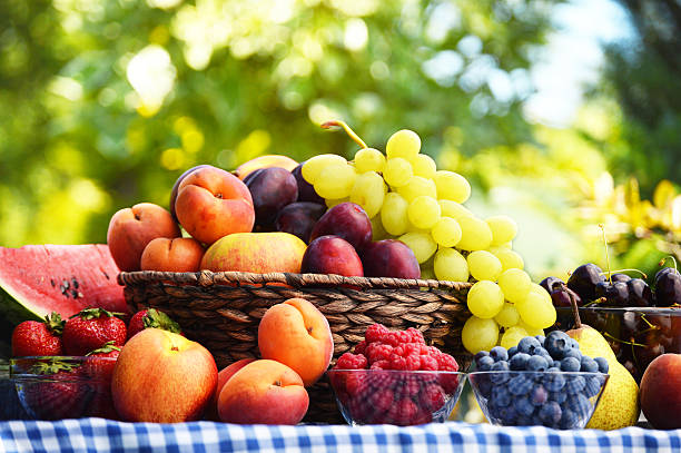 新鮮なオーガニックフルーツのバスケットの庭 - plum fruit basket wicker ストックフォトと�画像