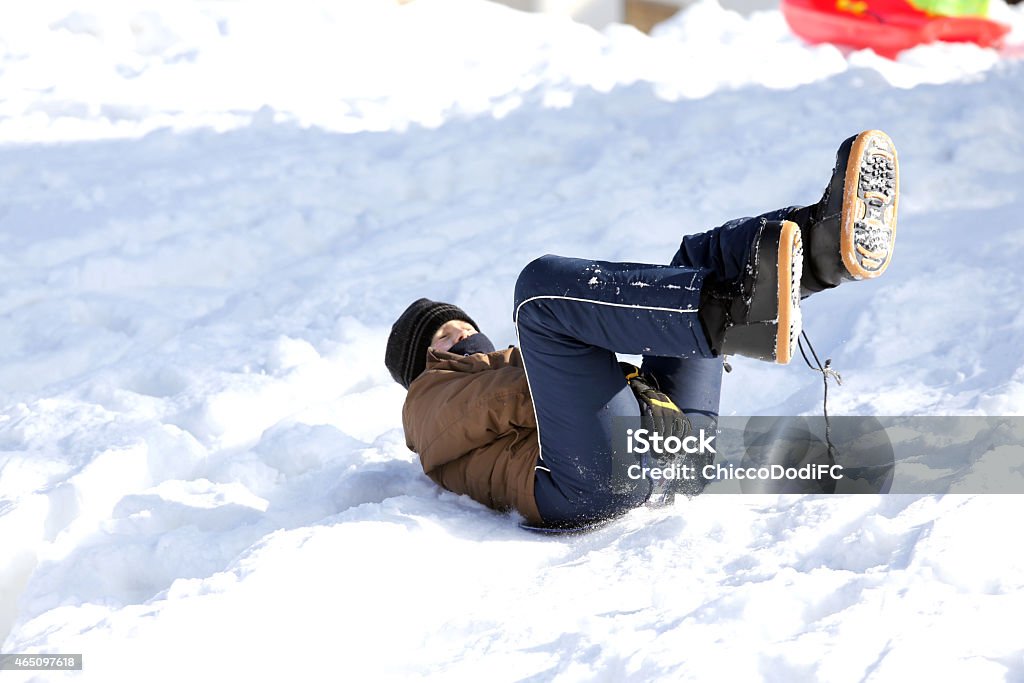 Niño juega con paseos en trineo en la nieve - Foto de stock de 2015 libre de derechos