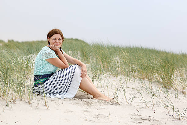 istock Young happy girl relaxing on sand dunes 465100681