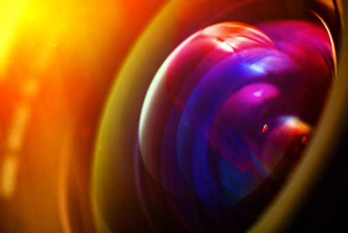Professional photo lens closeup with colorful reflections.