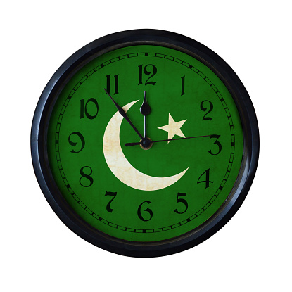 An old Pakistan flag wall clock with grungy background - isolated over white.