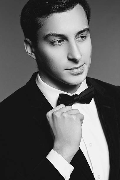 istock Handsome man in suit and bow tie on white background. 465102562