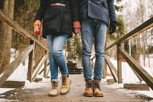 Couple holding hands standing in a winter forest straight stock photo