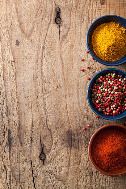 istock spices background: pink and black pepper, paprika powder, curry 465107615