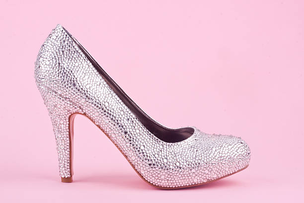 shiny high heel shoes with rhinestones on a pink background