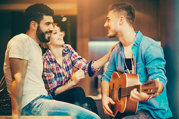 istock Three teenagers having fun with a guitar in a coffee bar 465109724