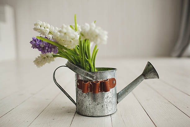 istock Old kettle with flowers on white wooden background 465109916