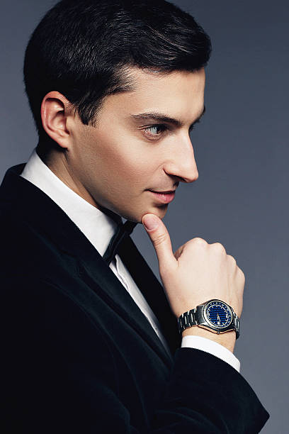 istock Handsome young man in suit with watch on white background. 465111828