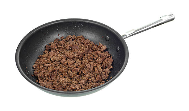 Skillet with cooked ground beef A skillet with a large portion of cooked ground beef on a white background. ground beef photos stock pictures, royalty-free photos & images