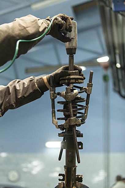 istock mechanic installs Shock Absorber 465113624