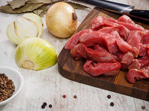istock raw meat slices on cutting board with pepper and onion 465117366
